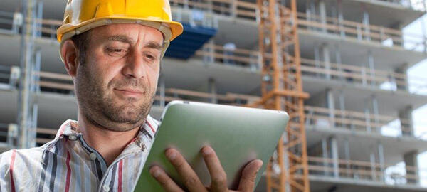 Bauarbeiter mit Tablet in der Hand auf Baustelle