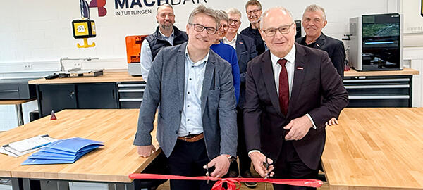 Präsident und Hauptgeschäftsführer durchschneiden rotes Band im Kreativraum in Tuttlingen. Im Hintergrund weitere Personen.