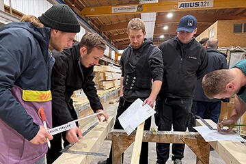 Studenten und Meistershcüler arbeiten gemeinsam an der Konstruktion eines Fachwerkknotens